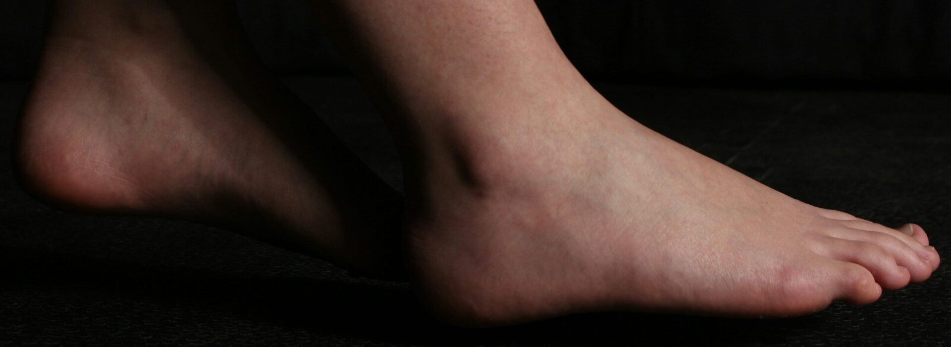 A bare foot is posing on black